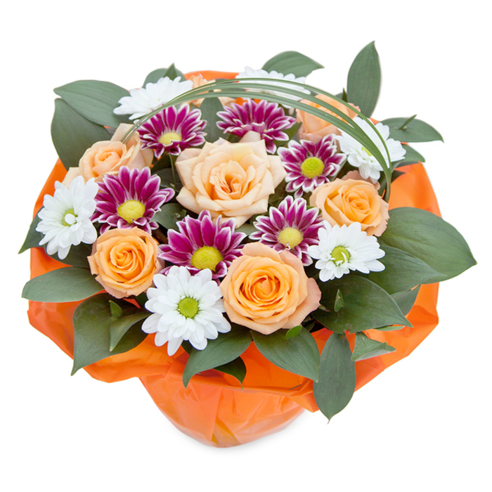 Blending classic floral artistry with the cheerful energy of Queensbury, this lush bouquet is captured from above, its vibrant colours and textures glowing against an immaculate white background. The heart of the arrangement pulses with several fully-open roses in a harmonious gradient from soft apricot to deep, sunny orange, each bloom layered with tightly furled petals that gradually unfold, reminiscent of the radiant blooms seen in local Queensbury gardens in full summer. Nestled among them are charming white chrysanthemums, their crisp petals arranged in dainty starbursts around luminous green centers, evoking the familiar beauty of wild daisies along local walking paths. Striking magenta and deep purple chrysanthemums bring a luxurious note, with their dense, finely textured petals and central discs in vivid green. Generous, glossy dark green leaves form a lush base, echoing the rich foliage found in the leafy avenues of Queensbury and neighbouring Stanmore. A fine arch of vivid green grass elegantly curves above, lending a sense of movement and modern sophistication. Wrapping the stems, a bold crinkled orange paper or cellophane nestles the bouquet, adding a tactile richness and unifying the arrangement's warm and cool tones. This bouquet, perfectly suited for life's meaningful moments in Queensbury-from anniversaries to lively community events-reflects the expertise and affectionate attention to detail of Queenbury's local floral designers.